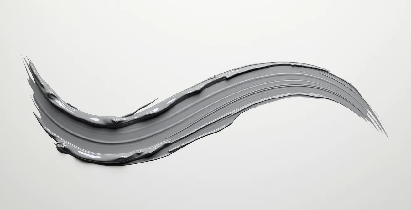 A single curved paint stroke showing a viscosity transition from thick impasto to a thin glaze